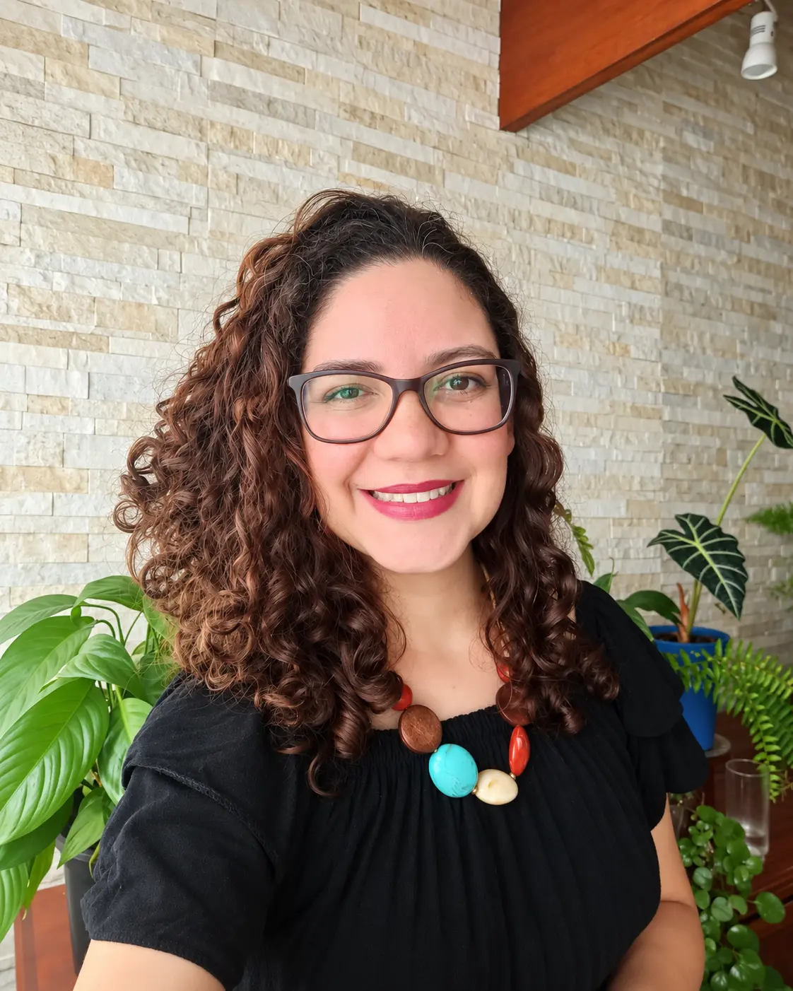 Selfi sonriente entre plantas y piedra